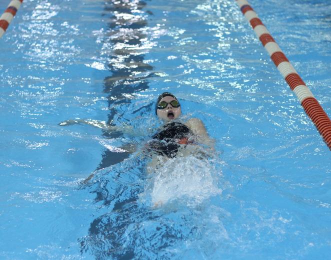 Junior Kelsey Inman swims the 100M backstroke in a home meet 