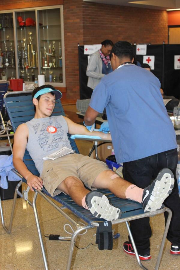 Senior+Lucas+Marroquin+donates+blood+in+the+lower+lobby+of+the+auditorium+on+October+26.+