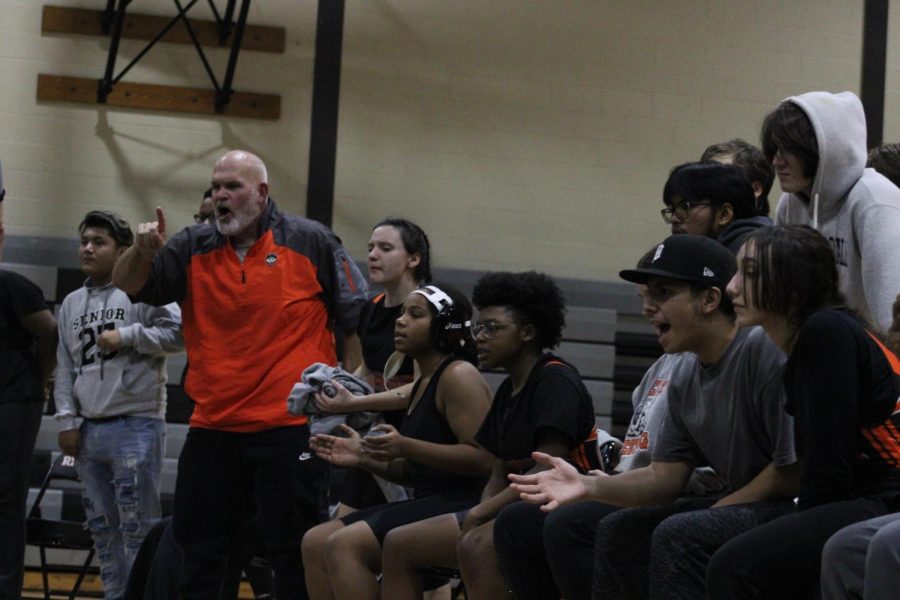 Wrestling Coach John Howard shouts instruction to his wrestlers during a meet. Athletic events can be intense experiences, and the pressure to do well comes from coaches, teammates, and fans. 