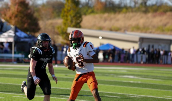 Quarterback Anthony Odom looks to throw downfield with a Pattonville defender on his heels.