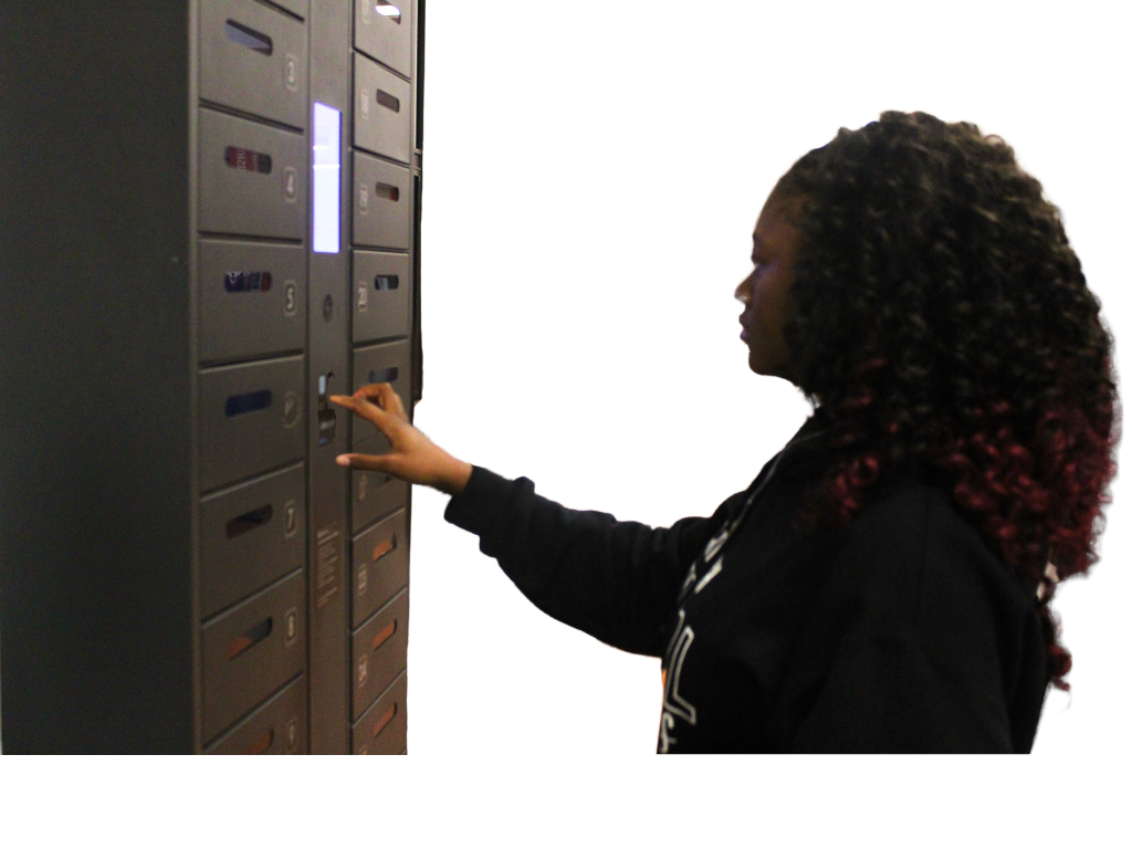 Junior Ayanna Burnett puts her phone inside the cell phone locker in the cafeteria. The lockers can be used by choice for students to charge their phones.